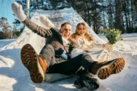couple in warm winter outfits posing on snowy ground