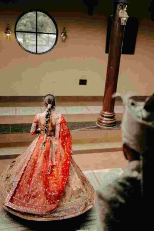The back drape bridal dupatta draping style: the embroidered border falls straight down the back, creating a striking cape silhouette for vidai photographs.