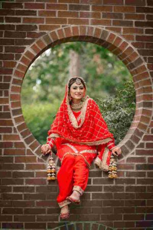 Indian bridal dupatta style varies by region. A Punjabi bride wearing a full head-draped dupatta — one of the most traditional Indian bridal dupatta styles.